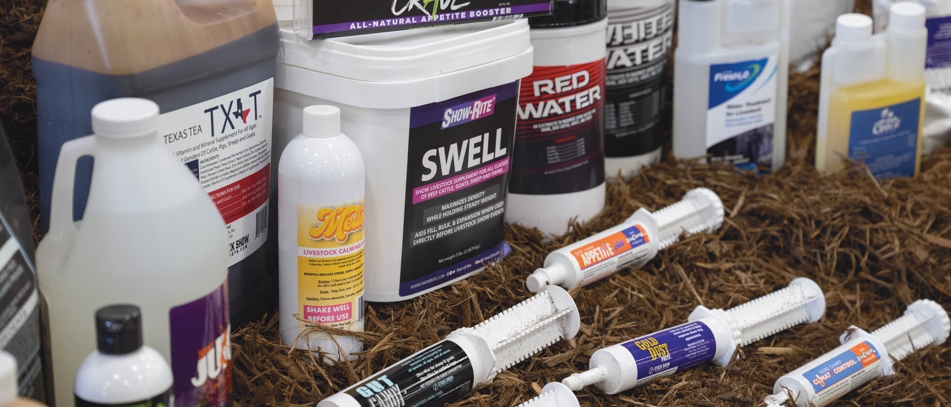 Livestock supplements and appetite boosters displayed on hay.